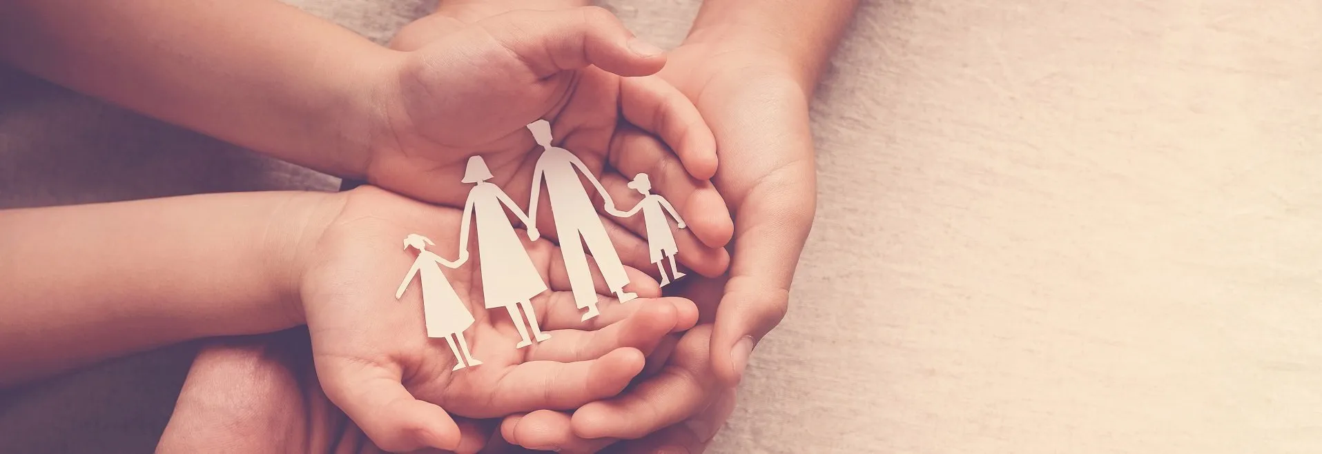 Adult and children hands holding paper family cutout, family home, foster care, homeless support concept